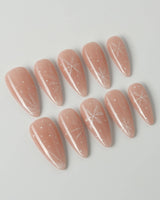 Frost Petals press-on nails in medium stiletto shape — Sheer Nude Pink, Delicate White Snowflakes.