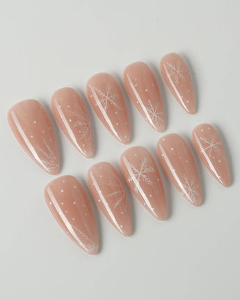 Frost Petals press-on nails in medium stiletto shape — Sheer Nude Pink, Delicate White Snowflakes.
