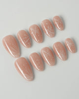 Frost Petals press-on nails in short almond shape — Sheer Nude Pink, Delicate White Snowflakes.