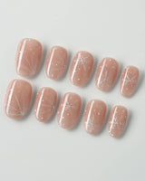 Frost Petals press-on nails in short oval shape — Sheer Nude Pink, Delicate White Snowflakes.