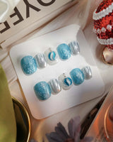 Frozen Dream press-on nails in extra short squoval shape — ice blue ombre silver chrome snowflake charm