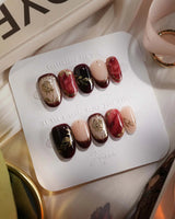 Gilded Merlot press-on nails with glossy merlot cat-eye, nude French tips and gold accents