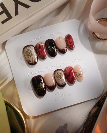 Gilded Merlot press-on nails with glossy merlot cat-eye, nude French tips and gold accents