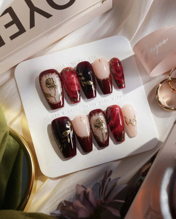 Gilded Merlot medium coffin press-on nails with burgundy cat-eye and gold rose accents