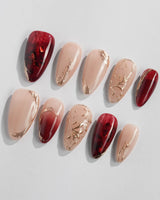 Gilded Rouge nail set with warm burgundy amber base and raised metallic gold leaf detail