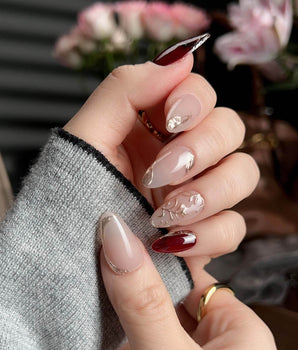 Gilded Rouge press-on nails with burgundy amber color and embossed gold leaf accents