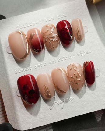 Gilded Rouge in short oval shape with burgundy amber finish and raised gold accents