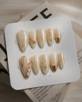 Gilded Truth press-on nails in medium almond shape — Minimalist Aurora White, Gold Metallic Outlines & Heart Illustrations.