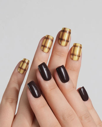 Close-up of Ginger Plaid nails with dark brown polish and lemon yellow plaid pattern