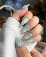 Glass Sea coastal nails with mint blue waves, glossy gel, and raised florals