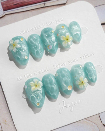 Glass Sea extra short almond nails with water shimmer, 3D flowers, and pearls