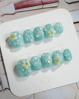 Glass Sea extra short squoval nails with aqua cat-eye ripples and 3D florals