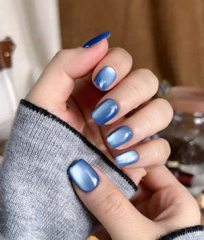 Glass Sky press-on nail set — deep ocean blue cat eye design, hand-painted with real gel polish