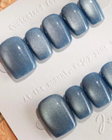 Glass Sky handmade press-on nails featuring deep ocean blue cat eye