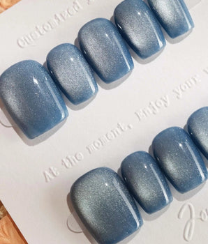 Glass Sky handmade press-on nails featuring deep ocean blue cat eye
