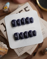 Glint Obsidian press-on nails in extra short coffin shape — deep indigo cat eye shimmer