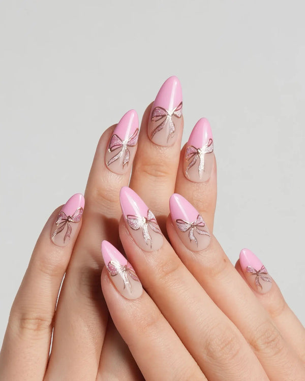 Glossy nude pink nails with golden ribbon accents