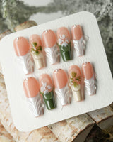 Duchess Olive nail close-up with olive green French styling and sculpted flower accents