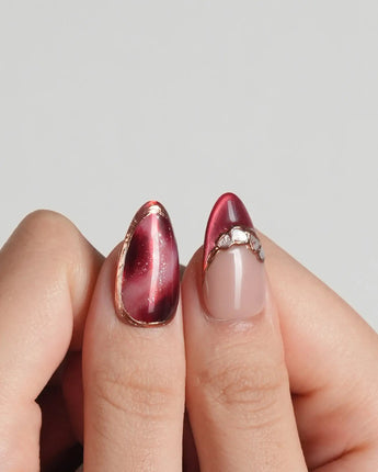 Molten Rouge press-on nails with nude base, deep red cat-eye tips and crystal accents