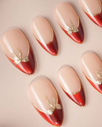 Bow French nail art close-up showing nude base red chrome french gold outline bow accent details