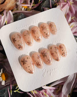 Glow Petals nail art close-up showing Gentle Nude Pink, Rose Gold Flowers & Gold Flakes. details