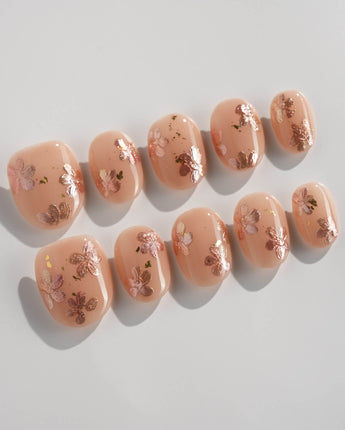 Glow Petals press-on nails in extra short oval shape — Gentle Nude Pink, Rose Gold Flowers & Gold Flakes.