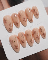 Glow Petals press-on nails in medium almond shape — Gentle Nude Pink, Rose Gold Flowers & Gold Flakes.