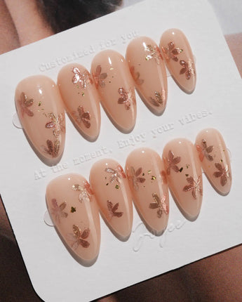 Glow Petals press-on nails in medium almond shape — Gentle Nude Pink, Rose Gold Flowers & Gold Flakes.
