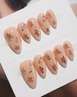 Glow Petals press-on nails in short almond shape — Gentle Nude Pink, Rose Gold Flowers & Gold Flakes.