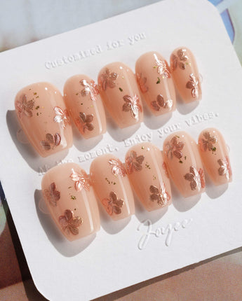 Glow Petals press-on nails in short coffin shape — Gentle Nude Pink, Rose Gold Flowers & Gold Flakes.