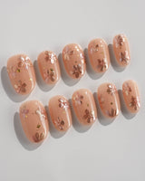 Glow Petals press-on nails in short oval shape — Gentle Nude Pink, Rose Gold Flowers & Gold Flakes.