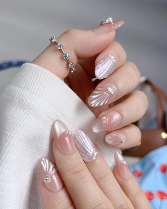 Glow Shore glossy beach-inspired press-on nails with soft sand tones and silver stars
