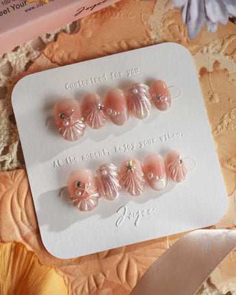 Glow Shore soft nude pink nails with dimensional shells and seaside sparkle