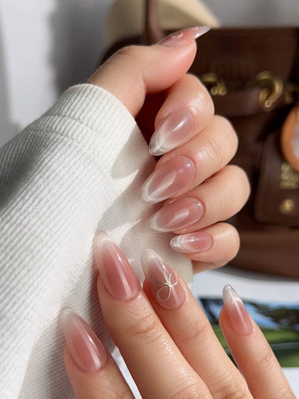 Almond-shaped French ombre press-on nails with gold bow

