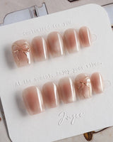 Glowing Blush press-on nails in extra short coffin shape — Transparent Blush Cat Eye, Simple Silver Bow Outline.