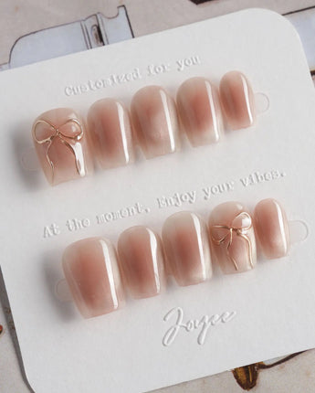 Glowing Blush press-on nails in extra short coffin shape — Transparent Blush Cat Eye, Simple Silver Bow Outline.