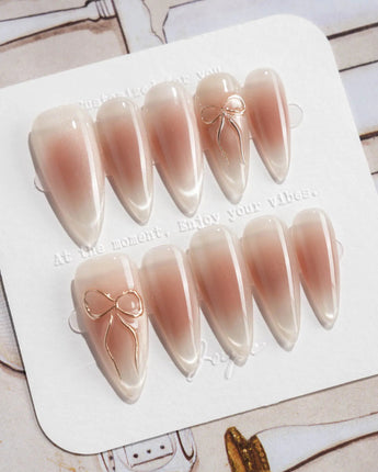 Glowing Blush press-on nails in medium stiletto shape — Transparent Blush Cat Eye, Simple Silver Bow Outline.
