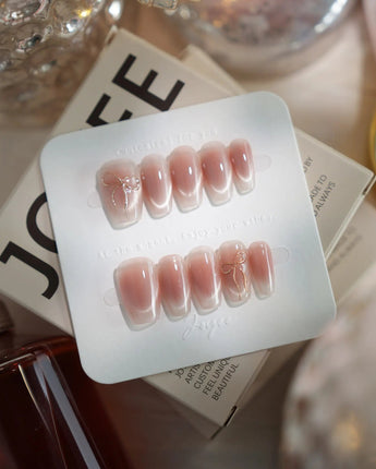 Glowing Blush press-on nails in short coffin shape — Transparent Blush Cat Eye, Simple Silver Bow Outline.