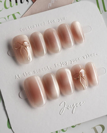 Glowing Blush press-on nails in short oval shape — Transparent Blush Cat Eye, Simple Silver Bow Outline.