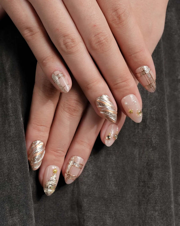 Gold Christmas press-on nails with bow and tree details