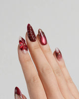 Lily Rouge press-on nails with nude base, red cat-eye shimmer and floral gel details