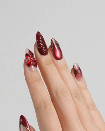 Lily Rouge press-on nails with nude base, red cat-eye shimmer and floral gel details