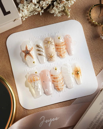 Golden Bay close-up of glossy shell nail art with gold wire flowers and shimmer
