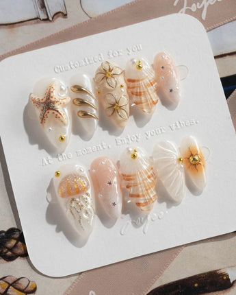 Golden Bay pearly milky white nails with 3D seashells and understated gold accents