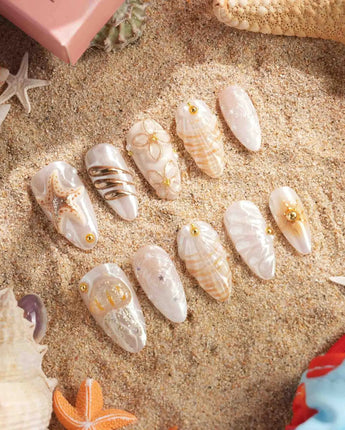 Golden Bay summer nails with shimmering blooms, shell accents, and soft white base