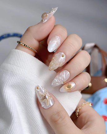 Golden Bay close-up of 3D shells and gold floral details on pearly white gel