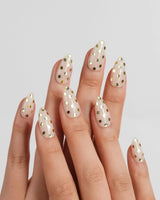 Golden Dot short almond nails with gold chrome polka dots on warm cream nude