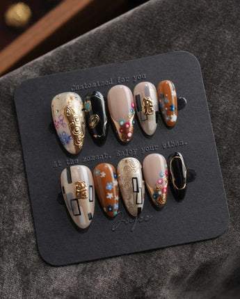 Golden Kiss L press-on nails in medium almond with hand-painted flowers and gold lines