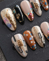 Golden Kiss S press-on nails in medium almond with Klimt-inspired gold patterning