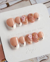 Golden Tide gold French tip floral press-on nails in extra short oval shape